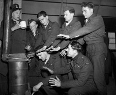 The crew of Lancaster "C for Charlie" of 44 Squadron try to warm themselves in their Nissen hut quarters at Dunholme Lodge, 2 March 1944 (c. Imperial War Museum)